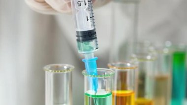 Enjeksiyon için kliniğin laboratuarındaki bir deney tüpünden alınan virüse karşı ilaç aşısıyla dolu iğneyle yakın çekim makro tıbbi şırınga. Koronavirüse karşı tedavi ve aşı