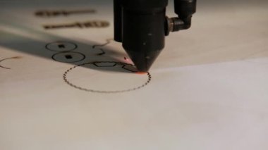 Tahta levha için lazer kesme makinesi. Modern bir CNC lazer kesme makinesi tahta bir levha kesiyor. Kesme işlemi sırasında lazer ışınından çıkan parlak kıvılcımlar