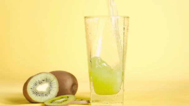 Gyümölcsszeleteket Tartalmazó Érett Kivi Organikus Gyümölcslevet Egy Színes Hátterű Koktélcsővel — Stock videók
