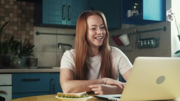 Веселая Молодая Женщина Рыжими Волосами Сидит Кухне Доме Работает Ноутбуком — стоковое видео