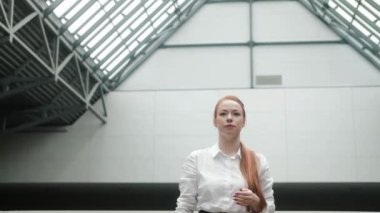 Resmi giyinmiş çekici beyaz iş kadını iş merkezine doğru yürür. Başarılı bir finans yöneticisi büyük bir şirkette bir ofiste çalışır. Bir iş kadını koridorda yürüyor.