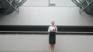 Resmi giyinmiş çekici beyaz iş kadını iş merkezinin büyük lobisinde duruyor. Başarılı bir yönetici bayan finansör büyük bir şirkette bir ofiste çalışıyor. Bir iş kadını koridoru