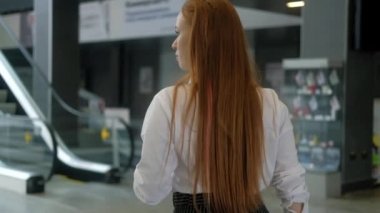 Başarılı genç iş kadını elinde bir fincan kahveyle bir iş merkezinin lobisinde yürüyor. Resmi kıyafetli büyük bir şirketin yöneticisi yürüyen merdivenden şirket ofisine çıkıyor.