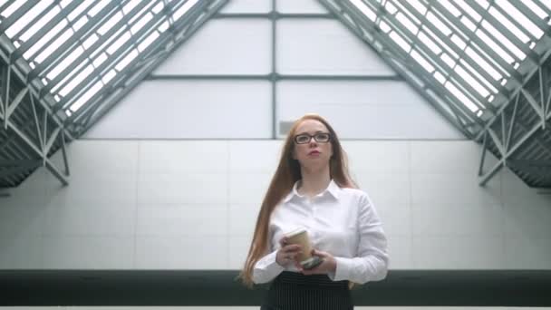 Başarılı Genç Kadını Elinde Bir Fincan Kahveyle Merkezinin Lobisinde Yürüyor — Stok video