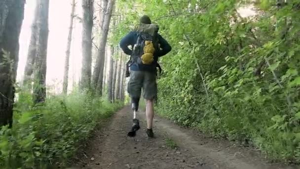 Hombre Discapacitado Con Extremidad Protésica Con Mochila Camina Por Bosque — Vídeo de stock