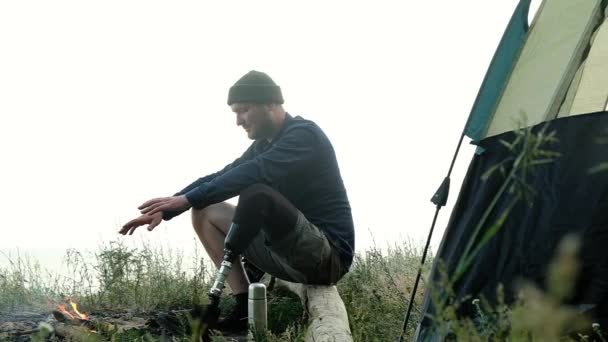 Vit Handikappad Man Med Protesben Sitter Stora Trästockar Skogen Nära — Stockvideo