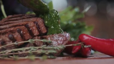 Izgara biftek. Mutfakta, ızgaradan alınan şeritlerle birlikte sulu kokulu et parçaları biberiye ve biberle pişiriliyor. Izgara et, lezzetli yeşil otlar ve baharatlarla doldurulur.