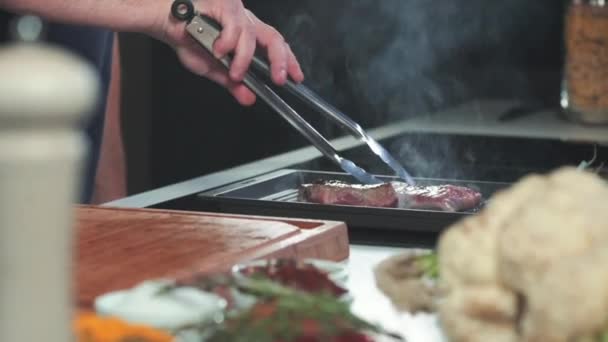 부엌에서 요리하는 맛있는 식사를 요리하기 위하여 뜨거운 요리를 생고기나 쇠고기 — 비디오