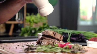 Mutfakta ızgara biftekler ve baharatlarla dolu. Pişirilmiş et parçaları biber kabından kokulu öğütülmüş biber ile pişirildi. Et pişirmek. Mutfakta barbekü.