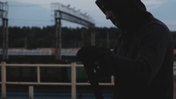 Çatıdaki Gri Kapüşonlu Genç Erkek Boksör Trenlerin Arka Planında Antrenman — Stok video