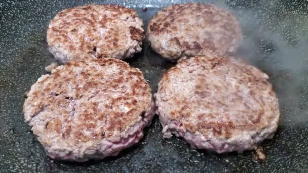 Vista de perto de carne hambúrguer cozinhar na superfície quente, comida americana saborosa 4k — Vídeo de Stock