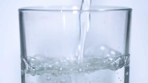 Διαφανές ποτήρι νερό ρίχνει αργή κίνηση, υγιεινό τρόπο ζωής ευεξίας πόσιμο — Αρχείο Βίντεο