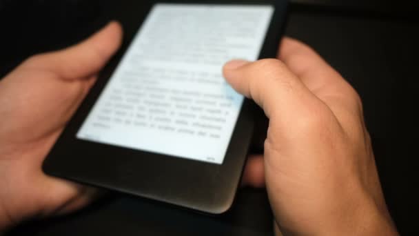 Młody człowiek korzystający z czytnika książek cyfrowych w domu, nowa technologia czytania książek — Wideo stockowe