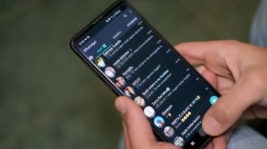 Young man while compulsive using social media apps on a smartphone,addiction