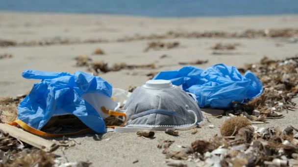 Man ta skyddsmask och plast handskar på havskusten, coronavirus förorening — Stockvideo