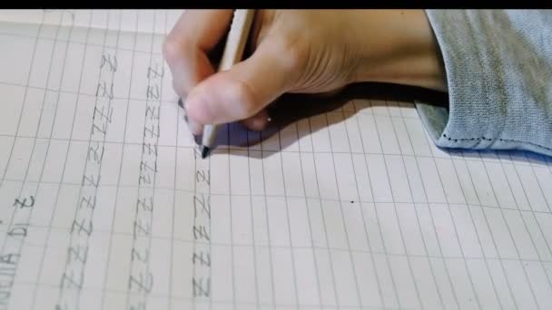 Close up of primary school kid doing homework writing on excercise book — Stock Video