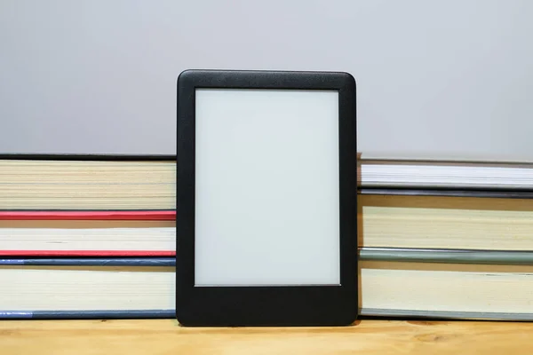 Digital e-book reader with classic paper books background,new knowledge technologies