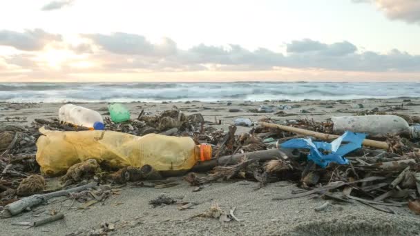 Plastik şişeler kirlenmiş okyanus kıyısındaki atık kirliliği, gün batımı zamanı, çevresel atıklar, zaman aşımı — Stok video