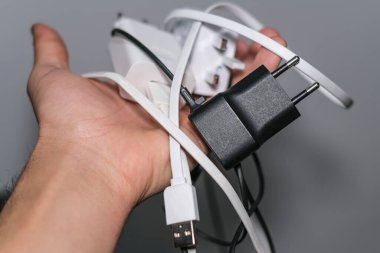 Bir grup akıllı telefonun el ele tutuşması şarj aletleri, teknolojik aletler.
