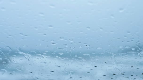 Regen water druppels op glas over onscherpe stormachtige zee achtergrond, klimaatverandering — Stockvideo
