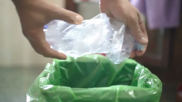 Mann sieht beim Müllwegwerfen gebrauchte Plastikflasche auf separatem Mülleimer, recyceln — Stockvideo