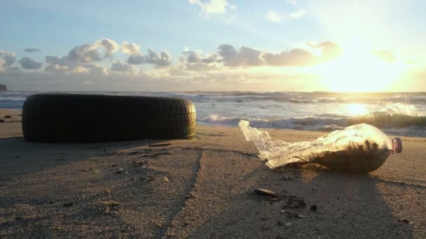 Old used rubber car tyre and plastic waste discarded on sea coast ecosystem,environmental pollution — Stock Video