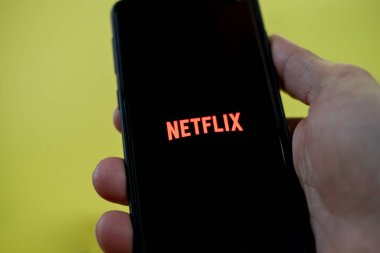 Akıllı telefonda Netflix uygulaması kullanırken adam el görüntüsü, video yayın platformu