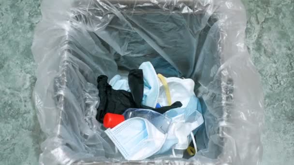Afzonderlijke vuilnisbak vol gebruikt beschermend gezichtsmasker en handschoenen, covid19 medisch afval — Stockvideo