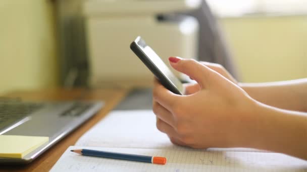 Vrouw gebruik smartphone tijdens het studeren thuis, sociaal netwerk tech verslaving — Stockvideo