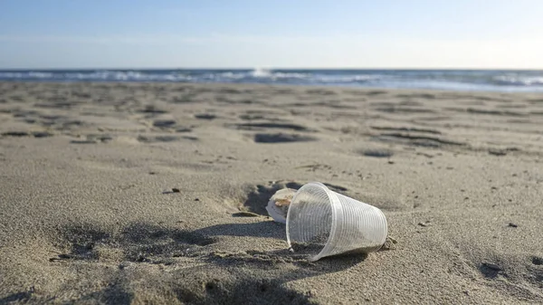 Vidro plástico descartável descartado no ecossistema da costa marítima, poluição por resíduos da natureza — Fotografia de Stock