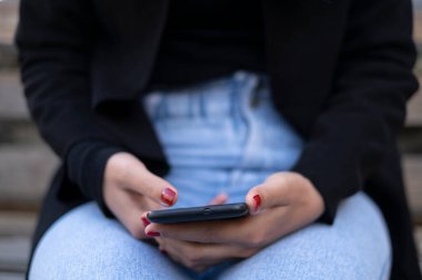 Genç Kadın, akıllı telefondan mesajlaşmak için akıllı telefon kullanıyor. Sosyal ağ teknolojisi bağımlılığı.