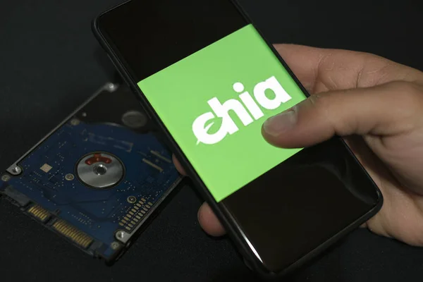 Man use Nova moeda criptomoeda verde Chia em um smartphone, hhd armazenamento moeda mineração agricultura — Fotografia de Stock