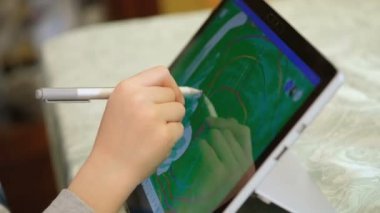 Çocuk uzak okul boyası çizimi ve çocuk eğitim teknolojisi için dijital grafik tableti kullanıyor.