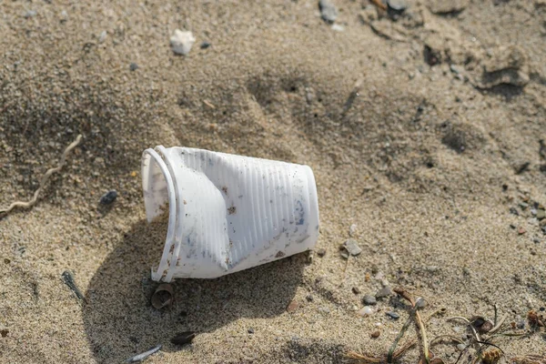 Copo de plástico descartável descartado no ecossistema da costa do mar, poluição por resíduos da natureza — Fotografia de Stock