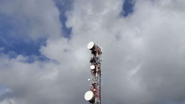 Penyiar telepon menara antena komunikasi melalui langit biru berawan, polusi gelombang elektromagnetik — Stok Video