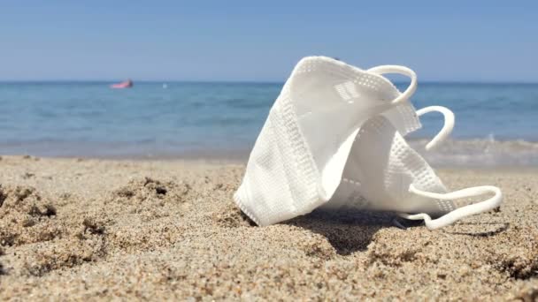 Protective face mask discarded on marine ecosystem with people swimming,covid pollution — Stock Video