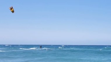 Okyanus dalgaları üzerinde uçurtma sörfü yapan sporcu yaz mevsiminde su sporları yapıyor.