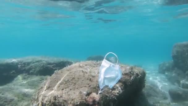 Ausrangierte chirurgische Gesichtsmaske schwimmt auf kontaminiertem Meeresökosystem, covid19 Umweltverschmutzung — Stockvideo