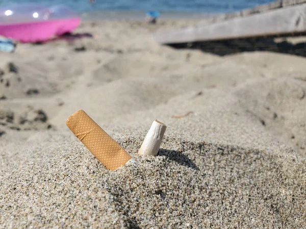 Butts de cigarro usados isolados descartados na praia de areia, poluição do habitat ecossistema — Fotografia de Stock