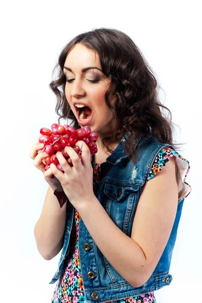 Молодая девушка ест виноград — стоковое фото