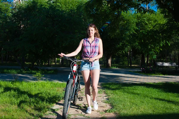 Chica caminando con su bicicleta — Foto de Stock