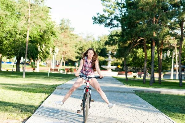 Chica sonriente montando en bicicleta — Foto de Stock