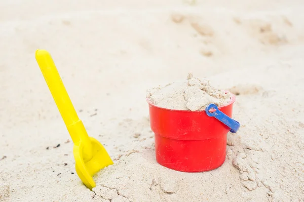 Red bucket and yellow spade — Stock Photo, Image