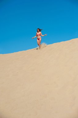 Kırmızı bikini kum üzerinde çalışan kız