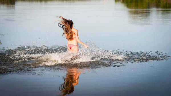 Menina de biquíni vermelho correr para a água — Fotografia de Stock