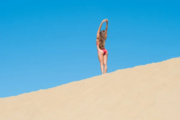 Girl in red bikini on sandy horizon — Stock Photo, Image