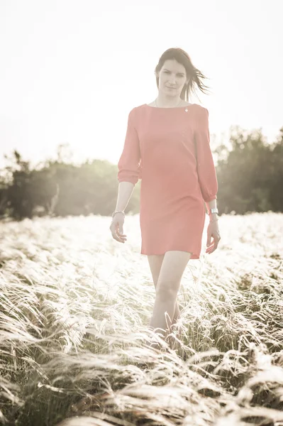 Красива жінка в перо-трава поля — стокове фото