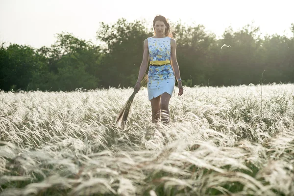 Pretty woman with bouquet of feather-grass — Stock Photo, Image