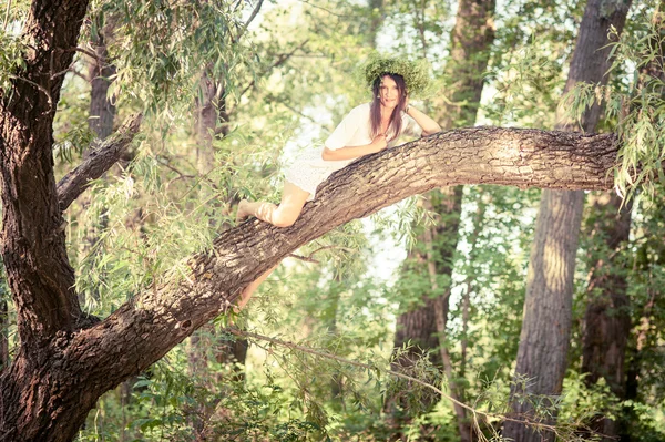 Mooie vrouw liggen op boom in fores — Stockfoto