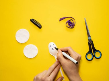 Sarı arka planda plastik kaşık ve pamuktan Paskalya tavşanı yapmak. Ev yapımı çocuk oyuncağı. Basit yaratıcı sanat projesi. Adım adım. Bahar için dekorasyon. Diy konsepti. Adım 2